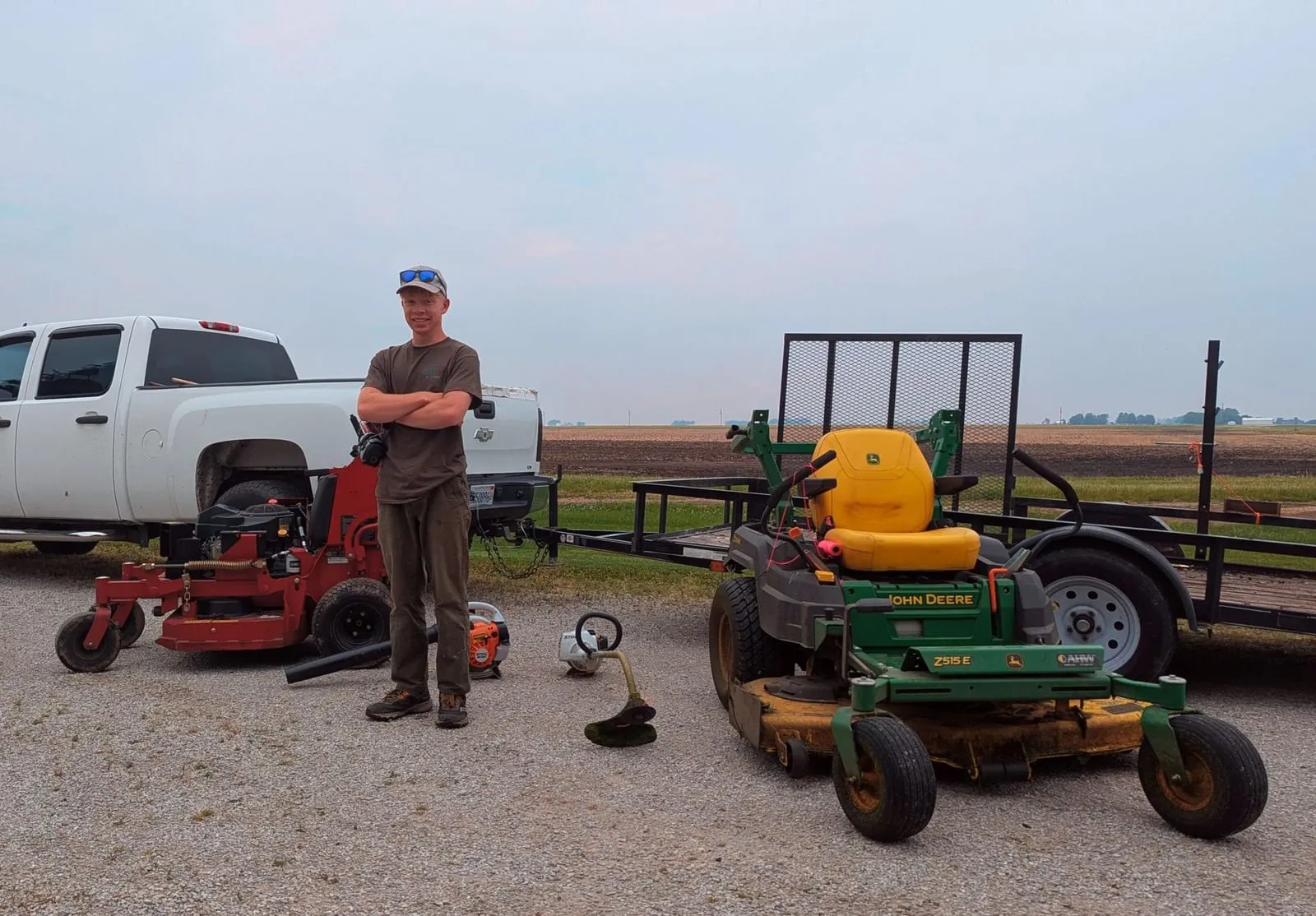 Russel with the pickup, trailer and commercial mowers the crew works from